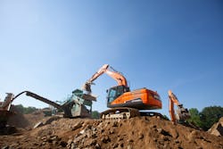 Excavators drop blasted rock and boulders into the crusher. Excavators drop blasted rock and boulders into the crusher.